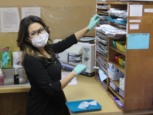 Cindy selects a tray in the sterilization room